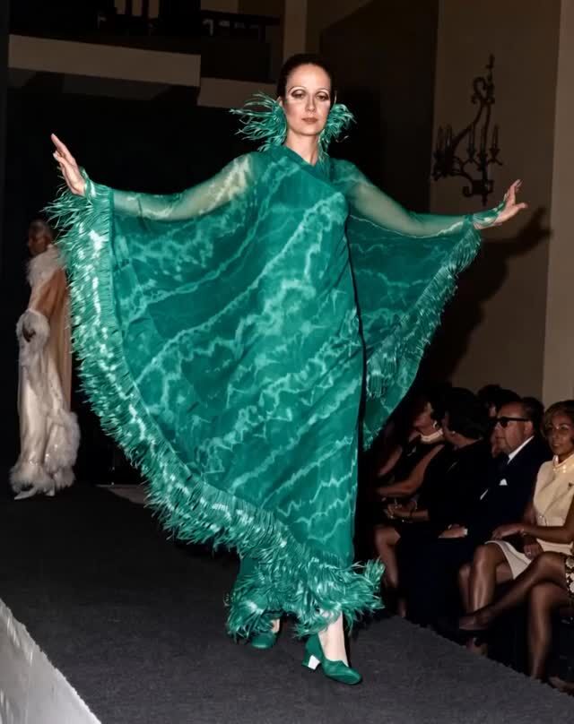 Forreau de noche en surah estampado en tonos esmeralda con capa-poncho de gasa del mismo color. Tocado y ribete de plumas de avestruz rematando el dobladillo de la capa. Desfile de #ManuelPertegaz en su primera gira americana de 1965. 

#altacostura #moda1965 #historiadelamoda #vintagefashion